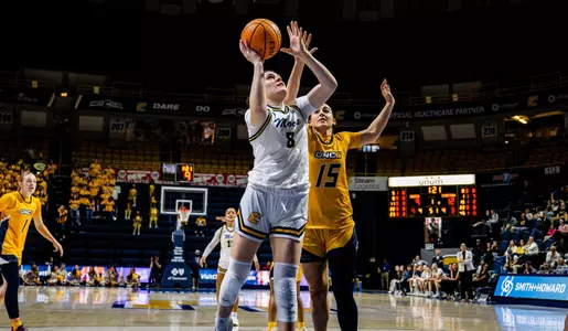 Evie Bruce driving to the basket at home against UNCG