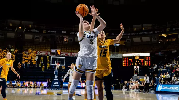 Evie Bruce driving to the basket at home against UNCG