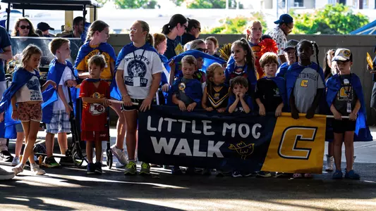 A large number of 12 and under Mocs fans gather behind their Little Moc Walk banner to lead the spirit parade at football tailgating.