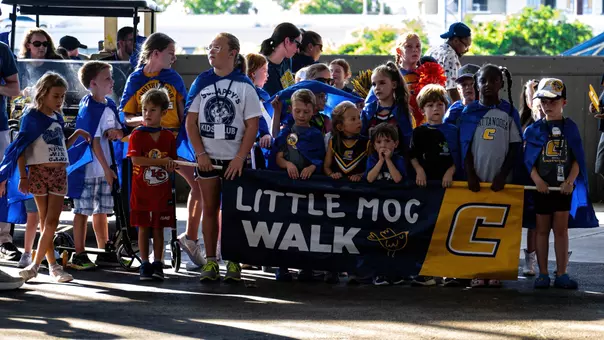 A large number of 12 and under Mocs fans gather behind their Little Moc Walk banner to lead the spirit parade at football tailgating.