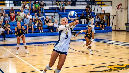 Caiti Barthel digs the ball near the sideline