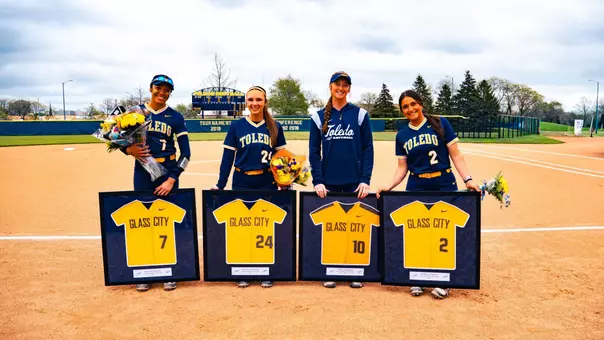 Toledo softball seniors Eli Enriquez, Madison McKay, Kylee Graham and Grace O'Malley posing with framed jerseys prior at Scott Park.