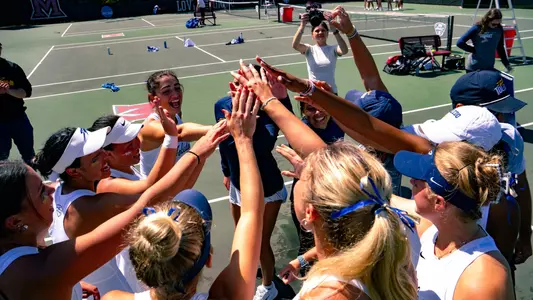 The Toledo women's tennis team huddles with their hands up