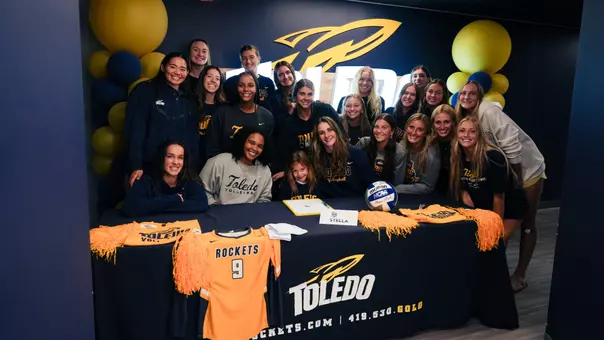 Stella Miller surrounded by the Toledo volleyball team during her Team IMPACT signing with the program