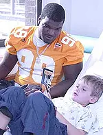 John Henderson visits with a patient today at Children's Hospital as the Vols went to four area hospitals Monday.