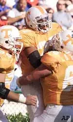 Troy Fleming (27) is congratulated by teammates Sean Young (66) and Demetrin Veal (96) after scoring a touchdown.