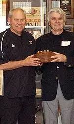 Coach Fulmer receives the ball from the family of Johnny Butler
