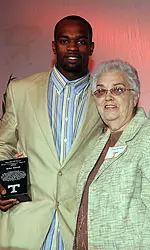 Two People Standing With Award Plaque