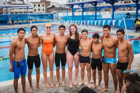 A Swim Team Standing In Front Of Pool