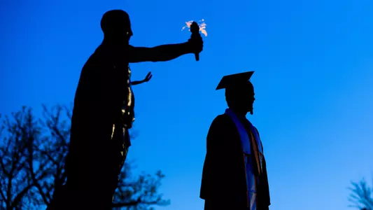 A senior has portraits made by the Torchbearer in Circle Park late in the evening