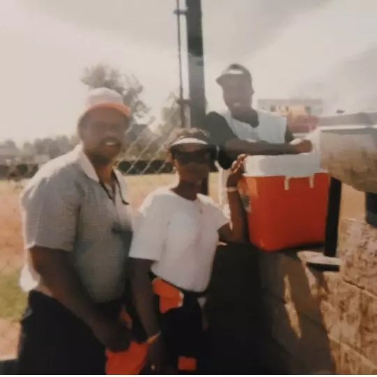 People Standing Next To A Cooler And Wall