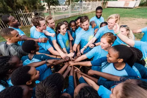 Group Huddle In Blue Shirts
