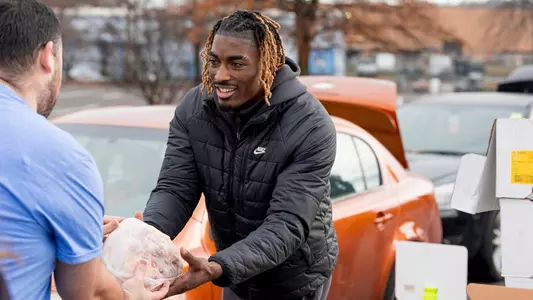 KNOXVILLE, TN - December 18, 2024 - Guard Jahmai Mashack #15 of the Tennessee Volunteers helps distribute food at a Second Harvest food drive in Knoxville, TN. Photo By Andrew Ferguson/Tennessee Athletics