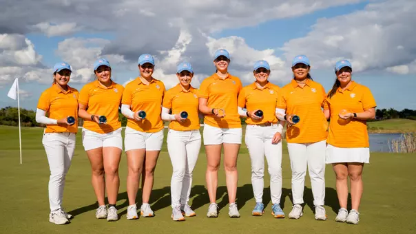 Eight members of the Tennessee women's golf program holding trophies following a team win at the Paradise Invitational in Boca Raton, Florida.