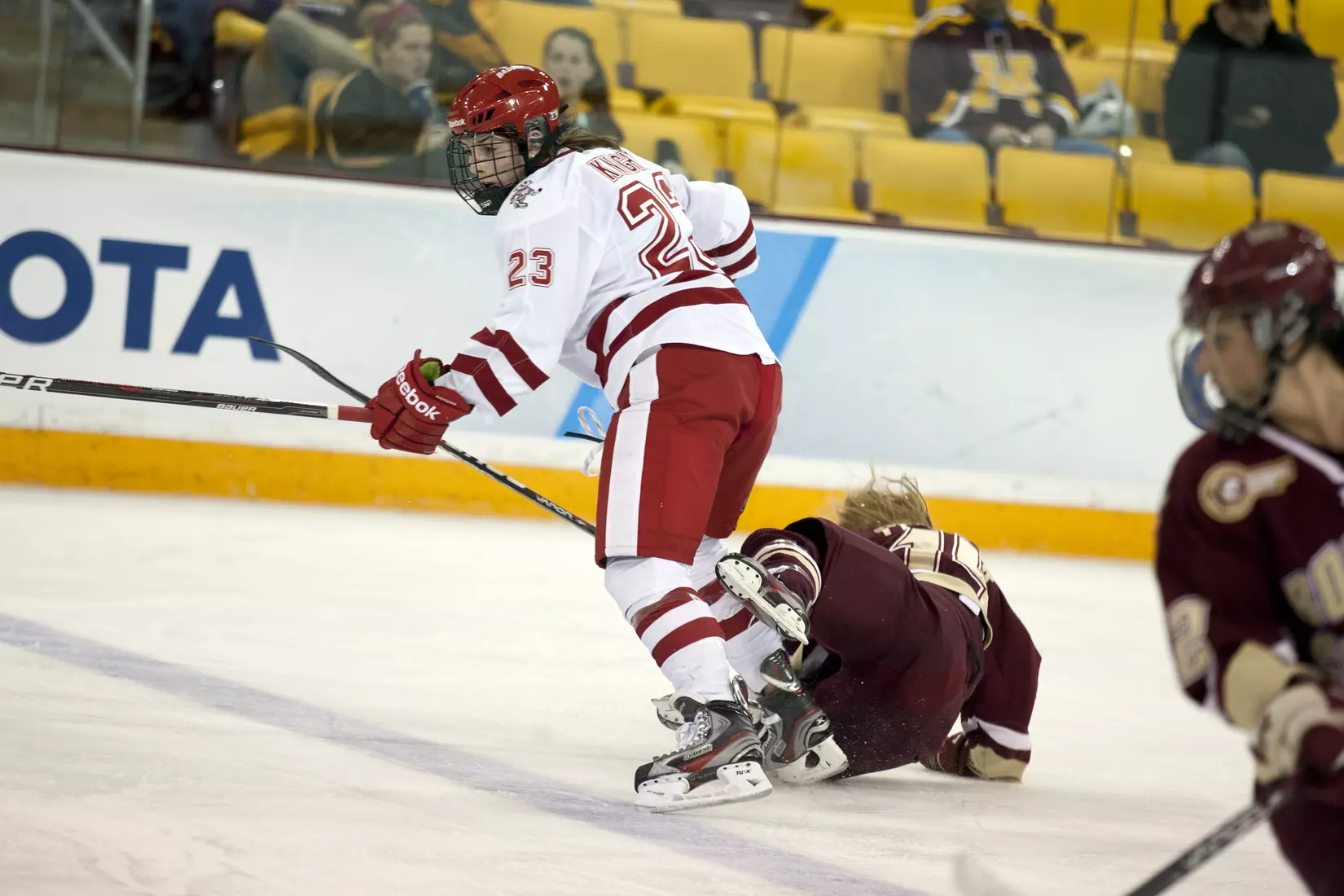 HIlary Kight (23) lands a hit on Boston College player Emily Field (15) during a Frozen Four semifinal game against Boston College Friday March 16, 2012 in Duluth, Minn.