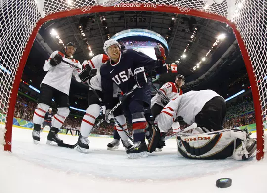 USA's Joe Pavelski, center, celebrates a goal by teammate Ryan Malone, not shown, in the second period of a preliminary round men's ice hockey game at the Vancouver 2010 Olympics in Vancouver, British Columbia, Tuesday, Feb. 16, 2010. Switzerland goalie Jonas Hiller is at right. USA won 3-1. (AP Photo/Hans Deryk, Pool)