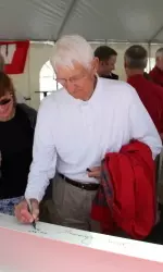 <b>A Badger supporter signs one of the beams that will be used in La Bahn Arena construction.</b>