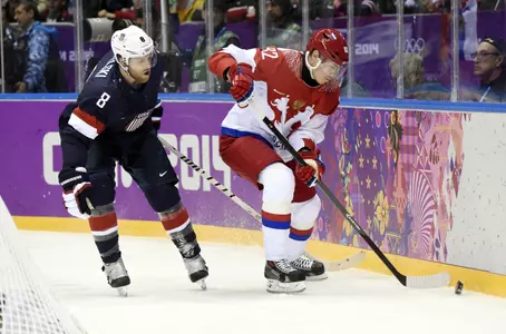 Feb 15, 2014; Sochi, RUSSIA; Russia defenseman Yevgeni Medvedev (82) battles for the puck along the boards with USA forward Joe Pavelski (8) in a men's preliminary round ice hockey game during the Sochi 2014 Olympic Winter Games at Bolshoy Ice Dome. Mandatory Credit: Scott Rovak-USA TODAY Sports