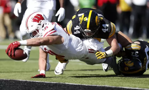 Wisconsin tight end Troy Fumagalli dives across the goal line ahead of Iowa's Ben Niemann (44) and Brandon Snyder, right, during a 17-yard touchdown reception in the first half of an NCAA college football game, Saturday, Oct. 22, 2016, in Iowa City, Iowa. (AP Photo/Charlie Neibergall)