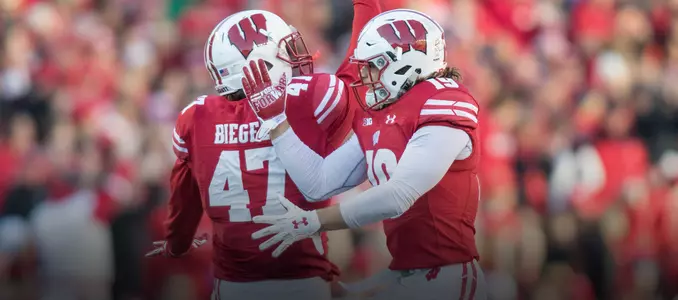 Leo Musso and Vince Biegel celebrate an interception vs. Illinois