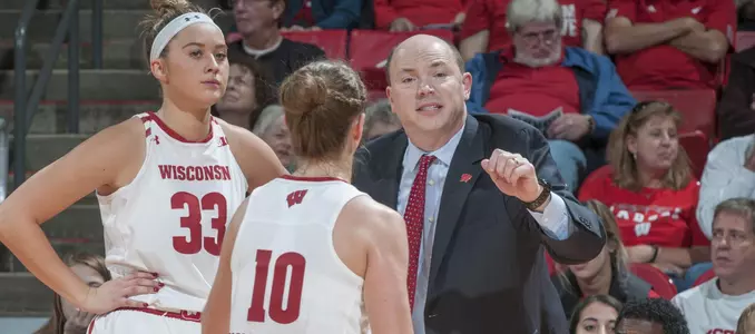 Coach Jonathan Tsipis talks to Courtney Fredrickson and Kendra Van Leeuwen