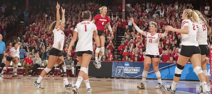 The Badger volleyball team celebrates on the court.