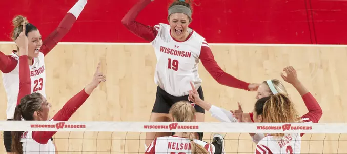 The Badger volleyball team celebrates on the court.
