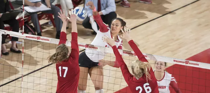 Tionna Williams attacks the ball against two Nebraska blockers.