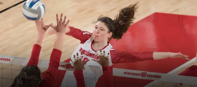 Dana Rettke attacks the ball against two Minnesota blockers