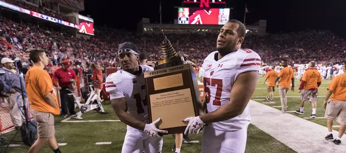 Photo of D'Cota Dixon, T.J. Edwards carrying Freedom trophy after football defeated Nebraska 2017