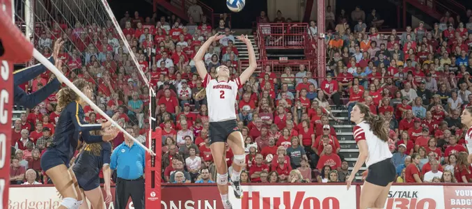 Sydney Hilley sets the ball to Dana Rettke behind her.