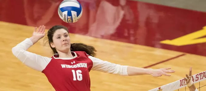 Dana Rettke attacks the ball against a blocker.