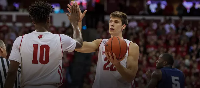 Ethan Happ high-fives Nigel Hayes during a game vs. Penn State