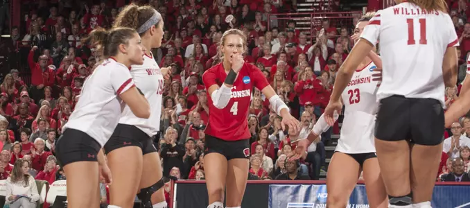 Five members of the Badgers celebrate on the volleyball court during a match in 2016.