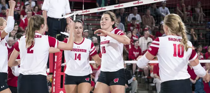 The Badger volleyball team celebrates a point on the court.