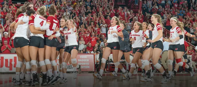 The Badger volleyball team celebrates its win over Marquette by gathering on the court.