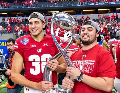 Photo of P.J. Rosowski and Rafael Gaglianone holding the 2017 Cotton Bowl trophy