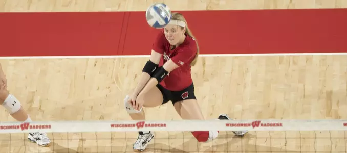 Tiffany Clark goes down to her knees to pass a ball.