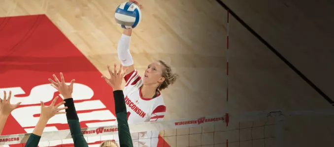 Kelli Bates attacks the ball against two MSU blockers.