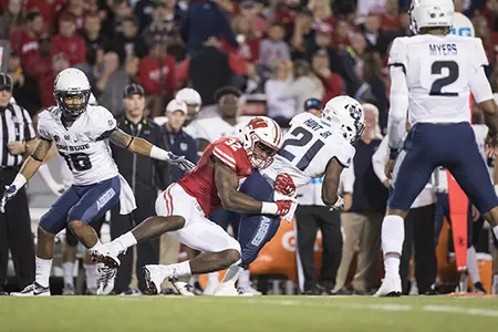Photo of Leon Jacobs tackling opponent during football game vs. Utah State 2017