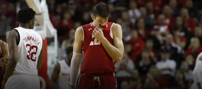 Ethan Happ wipes his face off with his jersey during a game at Nebraska