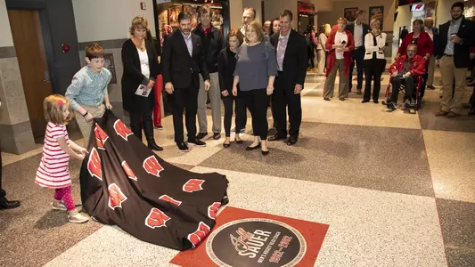 Children unveil the Jeff Sauer square in the Wisconsin Athletics Legends Walk at the Kohl Center, Oct. 17, 2018