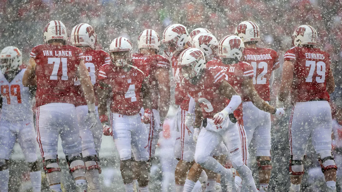 Wisconsin football team stands in the snow during game vs. Illinois 2018