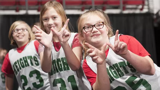 Three young girls show the W with their fingers