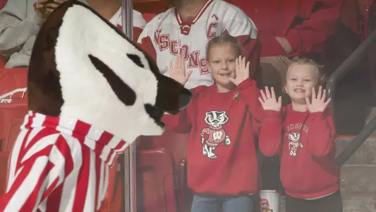 Bucky Badger skates in front of two little girls at men's hockey vs. Victoria exhibition game 2017