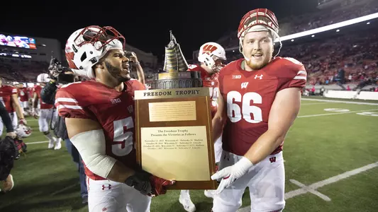 T.J. Edwards with Freedom Trophy and UW teammate after Wisconsin vs. Nebraska football game 2018