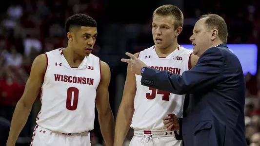 D'Mitrik Trice and Brad Davison talk to coach Greg Gard men's basketvall vs. Xavier 2018