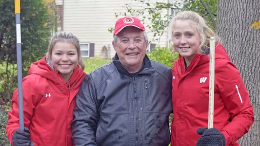 Badgers Give Back 'Leaf it to the Badgers' raking event 2018 - Jolie Fish (softball) and Madison Schwartz (softball) bond with former Badger football alum, Steve Underwood.