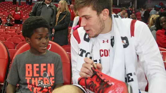 Ethan Happ with child for shoe project 2018 Badgers Give Back