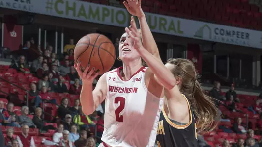 Kelly Karlis drives to the basket past an Oshkosh defender.